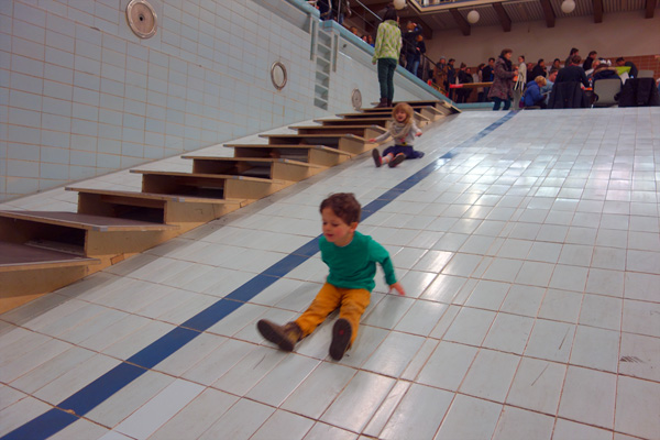 kids playing on the slope of the former swimming pool